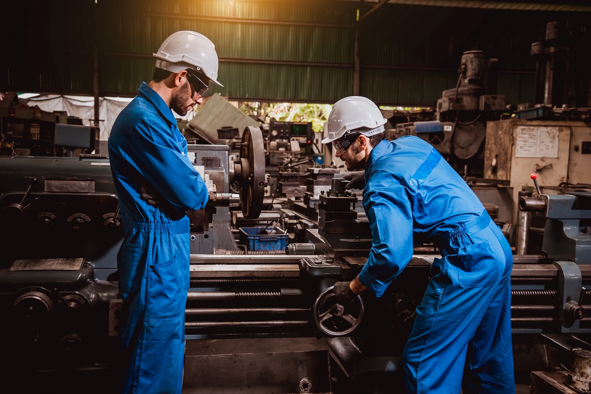 two men in safety gear working in a factory