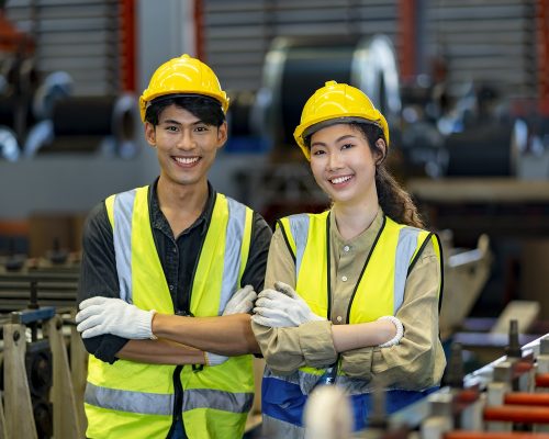 two factory workers wearing yellow hard hats